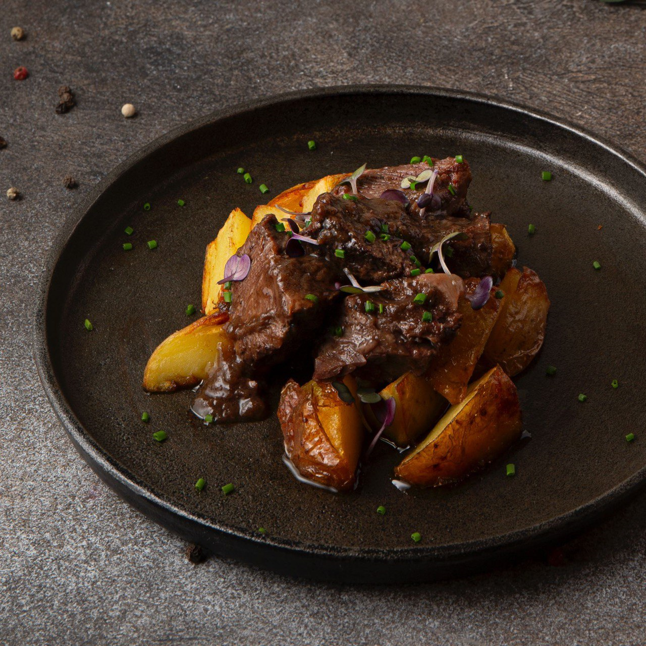 Томленые щечки с печеным картофлем и перечным соусом